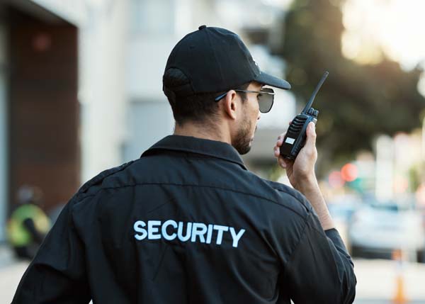 Cropped portrait of an attractive young female construction worker using a cellphone while standing outside with her team in the background